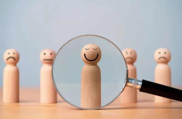 Smiley face on wooden figure with inside magnifier glass for focus of satisfy and happiness of excellent customer evaluation concept.