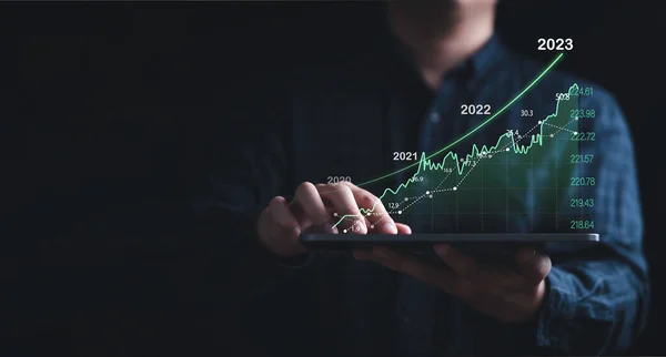 Investor holding tablet with increasing stock market graph chart for trader technical analysis concept.