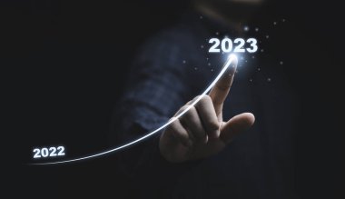 İş adamı el çizimi 2022 'den 2023' e yükselen ok için Mutlu Noeller ve mutlu yıllar konsepti için.
