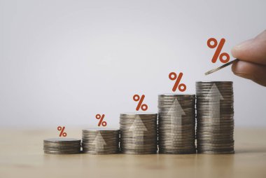 Increasing coin stacking with up arrow and percentage sign for increase financial interest rate and business investment growth from dividend concept.