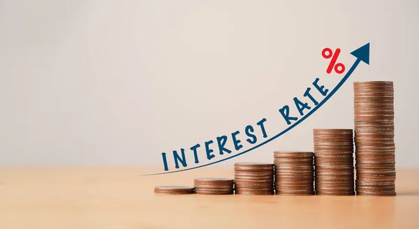 Madeni paraların okla istiflenmesi ve finansal planlama ve faiz oranı büyüme konsepti için ahşap masa üzerindeki yüzdenin artırılması.