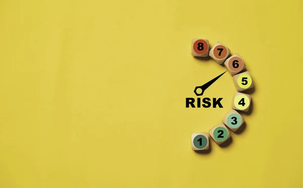 Risk level indicator rating print screen wooden cube block since low to high on yellow background for Risk management and assessment concept.