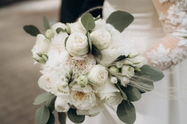 Güzel gelin elinde beyaz buket tutuyor. Kadınların elinde beyaz güllerden bir buket