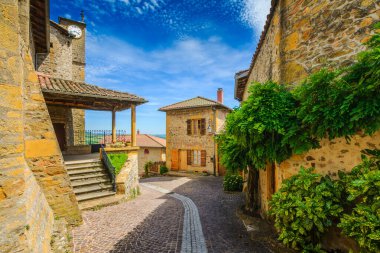 In the street of the medieval village Ternand in France during a sunny day clipart