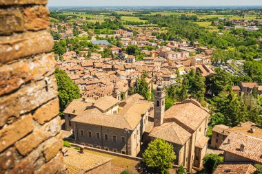 İtalya Piacenza 'daki Castell' Arquato ortaçağ kasabasının panoramik hava manzarası tuğla evler bulutlar bulutlar güzel gökyüzü ve ormanlık arazi