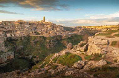 Materalı Sassi 'nin muhteşem panoramik manzarası. Önünde kayalar, gün batımında taş şehir, Basilicata, İtalya.