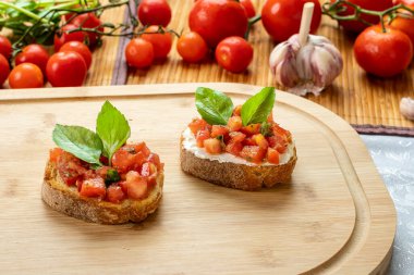 Tahtada domates, ricotta ve fesleğenli bruschetta.