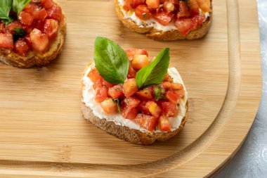 Tahtada domates, ricotta ve fesleğenli bruschetta.