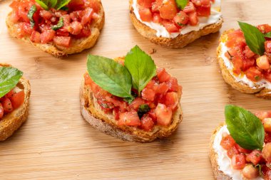 Tahtada domates, ricotta ve fesleğenli bruschetta.
