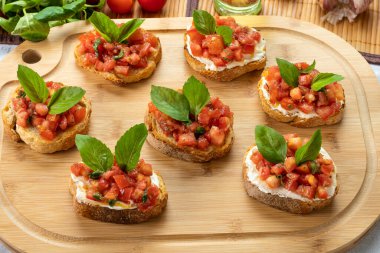 Tahtada domates, ricotta ve fesleğenli bruschetta.