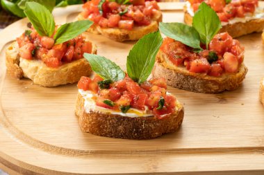 Tahtada domates, ricotta ve fesleğenli bruschetta.