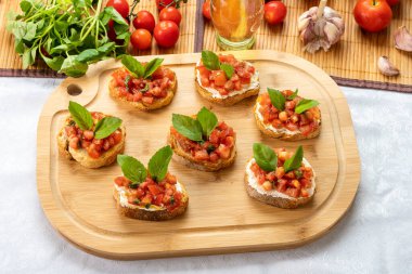 Tahtada domates, ricotta ve fesleğenli bruschetta.