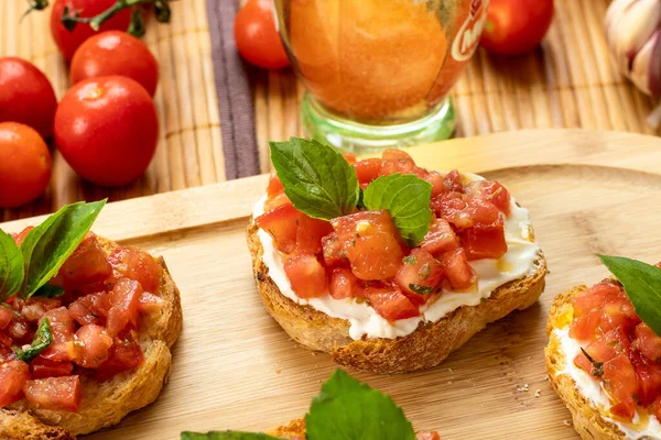 Tahtada domates, ricotta ve fesleğenli bruschetta.