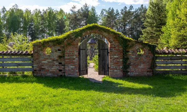 石の壁 木製の門 聖書の庭への入り口 庭の春 植物で覆われた古いレンガの壁 — ストック写真
