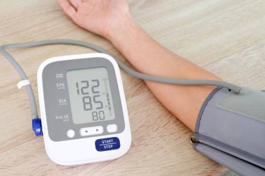 İnsan tansiyon monitörü ve kalp atış hızı monitörünü dijital basınç göstergesiyle kontrol eder. Sağlık ve Tıp Konsepti
