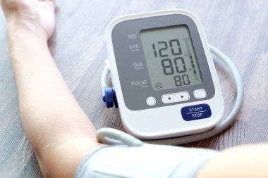 İnsan tansiyon monitörü ve kalp atış hızı monitörünü dijital basınç göstergesiyle kontrol eder. Sağlık ve Tıp Konsepti