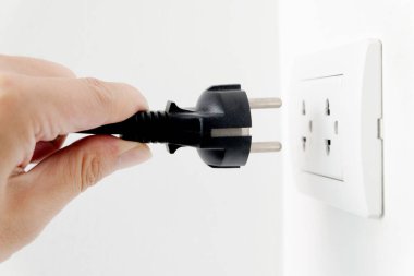 Elektrik Cihazları 'nın Eli fişi çekiyordu. Fişi çek. Çalışma saatlerinde ofisinde. Enerji Tasarruf Kavramları ve Teknolojileri