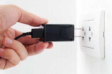 Elektrik Cihazları 'nın Eli fişi çekiyordu. Fişi çek. Çalışma saatlerinde ofisinde. Enerji Tasarruf Kavramları ve Teknolojileri