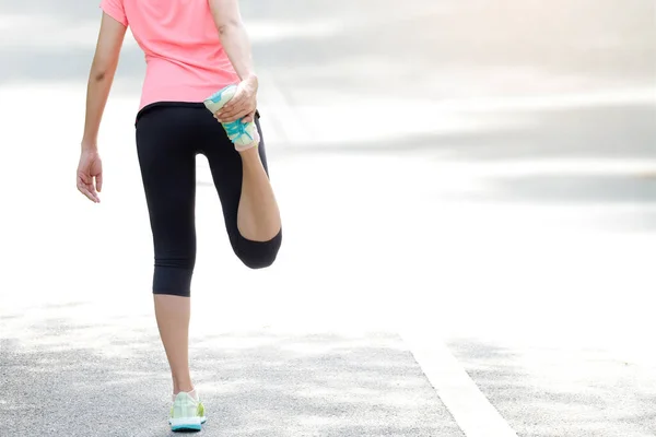 靴を履いて運動をする公園の道路を走る女性の体が美しく太ももの筋肉を伸ばしていました 健康とスポーツの概念の背景 — ストック写真