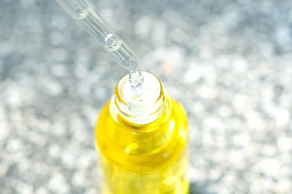 透明な黄色のボトル柔らかい光の背景に顔の血清コラーゲン保湿剤をドロップします 保護肌トリートメントフェイシャルエッセンスオイル ビタミンC — ストック写真