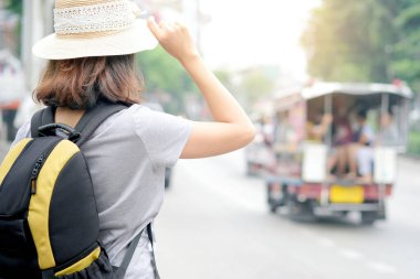 Yol kenarında sırt çantasıyla gezen güzel bayan turist tatilde bir araba arıyor.