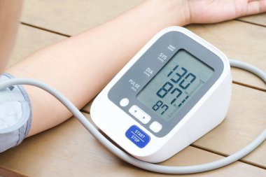 İnsan tansiyon monitörü ve kalp atış hızı monitörünü dijital basınç göstergesiyle kontrol eder. Sağlık ve Tıp Konsepti