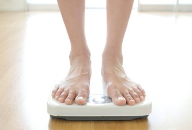 Erkeklerin bacakları terazinin üzerinde duruyor. Sağlık ve kilo kaybı kavramı.