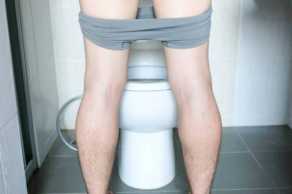 家のトイレで便器を覗き立っている男の後ろ姿 健康コンセプト — ストック写真