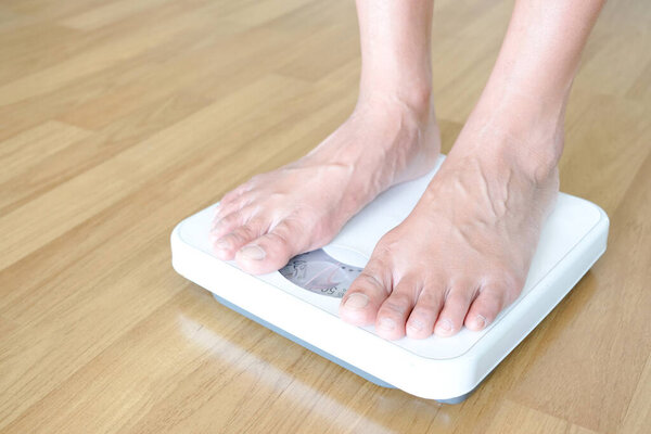 Legs of men standing on scales weight. Concept of health and weight loss.