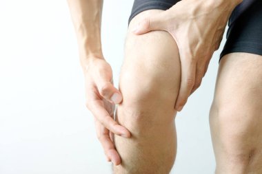 Diz ağrısı. Kadın çimlerin üzerinde duruyor. Eli dizinden sıkıştı. Acıyı dindirmek için ayaklarının ağrıması ve kaslarının yorulması. sağlık kavramları.