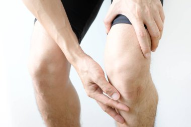 Diz ağrısı. Kadın çimlerin üzerinde duruyor. Eli dizinden sıkıştı. Acıyı dindirmek için ayaklarının ağrıması ve kaslarının yorulması. sağlık kavramları.