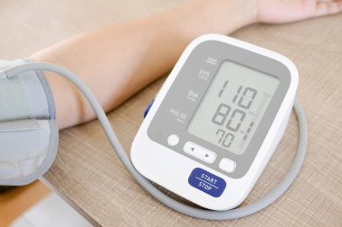 İnsan tansiyon monitörü ve kalp atış hızı monitörünü dijital basınç göstergesiyle kontrol eder. Sağlık ve Tıp Konsepti