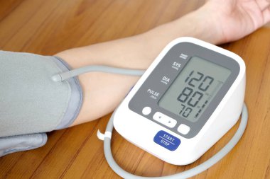 İnsan tansiyon monitörü ve kalp atış hızı monitörünü dijital basınç göstergesiyle kontrol eder. Sağlık ve Tıp Konsepti