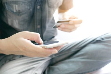 Modern kadın yaşam tarzı. Oturma odasında onun tabletini kullanıyor ve internetten mal almak için kredi kartını tutuyor.