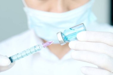 Hand of doctor holding syringe and medicine bottle. Preparing for injection