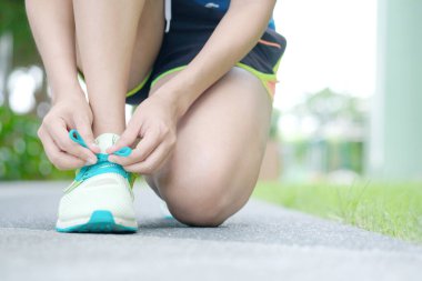 Kadın egzersiz koşusu. Koşu pistinde ayakkabı bağcıkları bağlıyor. Sağlık ve Spor Konsepti.