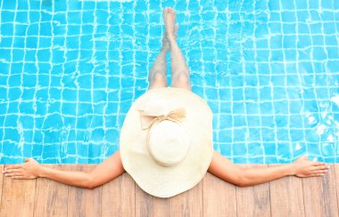 Hafta sonları lüks bir tatil köyünde, ahşap zeminde güzel kadın bacakları ve ayakları. Güzelliği ve cildin sulanmasını hesaba katın..