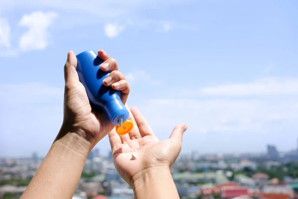 Mão Mulher Segurando Protetor Solar Muito Luz Sol Céu Fundo — Fotografia de Stock