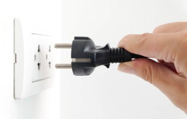 Elektrik Cihazları 'nın Eli fişi çekiyordu. Fişi çek. Çalışma saatlerinde ofisinde. Enerji Tasarruf Kavramları ve Teknolojileri