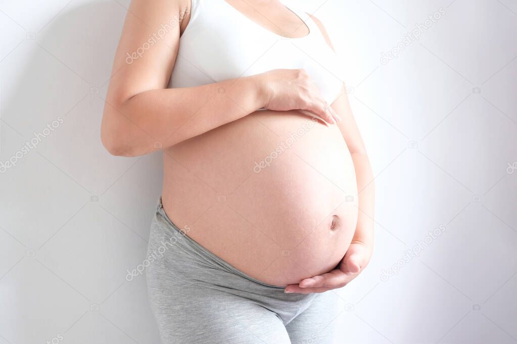She have a baby. Woman is pregnant touching belly with love of mother and baby. Relationship during family concept , Health concept.