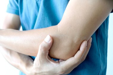 Erkekler dirseklerini tutmak için ellerini kullanır ve dirseklerinde ağrı vardı. Acı verici Sağlık ve Tıbbi Konseptler