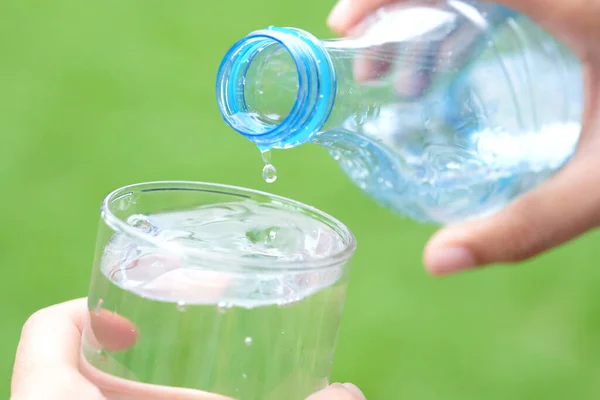 Healthy lifestyle Pour pure water from a bottle of mineral water into a glass.Health concept