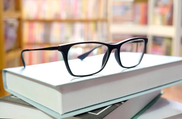 Kütüphaneye yerleştirilmiş gözlük ve kitaplar