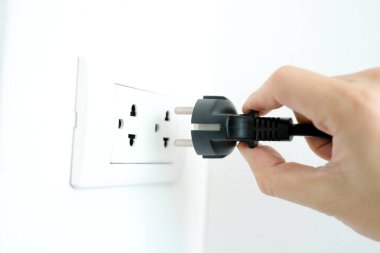 Elektrik Cihazları 'nın Eli fişi çekiyordu. Fişi çek. Çalışma saatlerinde ofisinde. Enerji Tasarruf Kavramları ve Teknolojileri