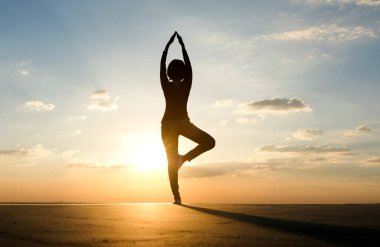 Güzel kadın sabah pozunda meditasyon ve yoga yapıyor. Güzel gündoğumuyla