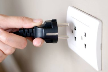 Elektrik Cihazları 'nın Eli fişi çekiyordu. Fişi çek. Çalışma saatlerinde ofisinde. Enerji Tasarruf Kavramları ve Teknolojileri