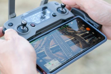 5 Kasım 2018 'de Bangkok' ta bir adamın elleri. Akıllı telefona bağlanan uzaktan kumandayı kullan. Fotokopi makinesini zorla. İnsansız hava aracı trafiğin yükseldiği açıyı yakalıyor.