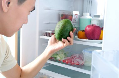 Erkekler sağlıklı olmak için malzeme seçerler, avokado tutarak sağlıklı besin elde ederler. Sağlıklı beslenme, buzdolabının içinde meyve, sebze, elma, çilek, domates ve üzümden oluşur..