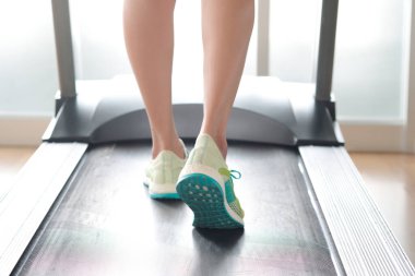 Spor salonunda koşu bandında koşan kadının bacağı koşu ayakkabılarıyla atletik koşuyor. Sağlık ve spor konsepti geçmişi,