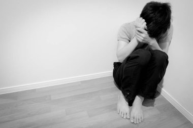 Odanın köşesinde oturan adamın duygusal ve zihinsel sorunları var. Toplumdan gelen depresyon ve stres var.